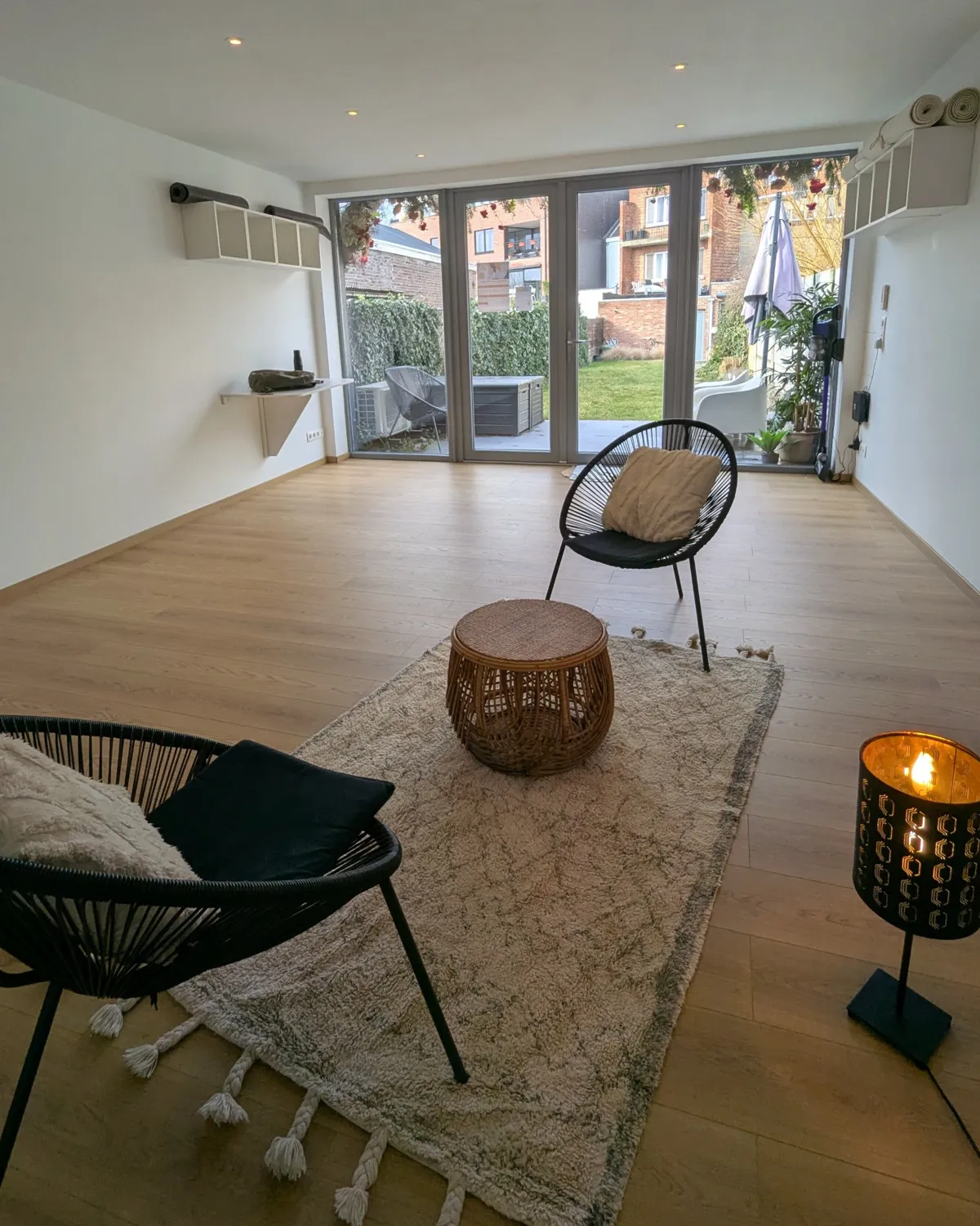 The practice room in Kessel-Lo with two chairs, a rug and a view of the garden